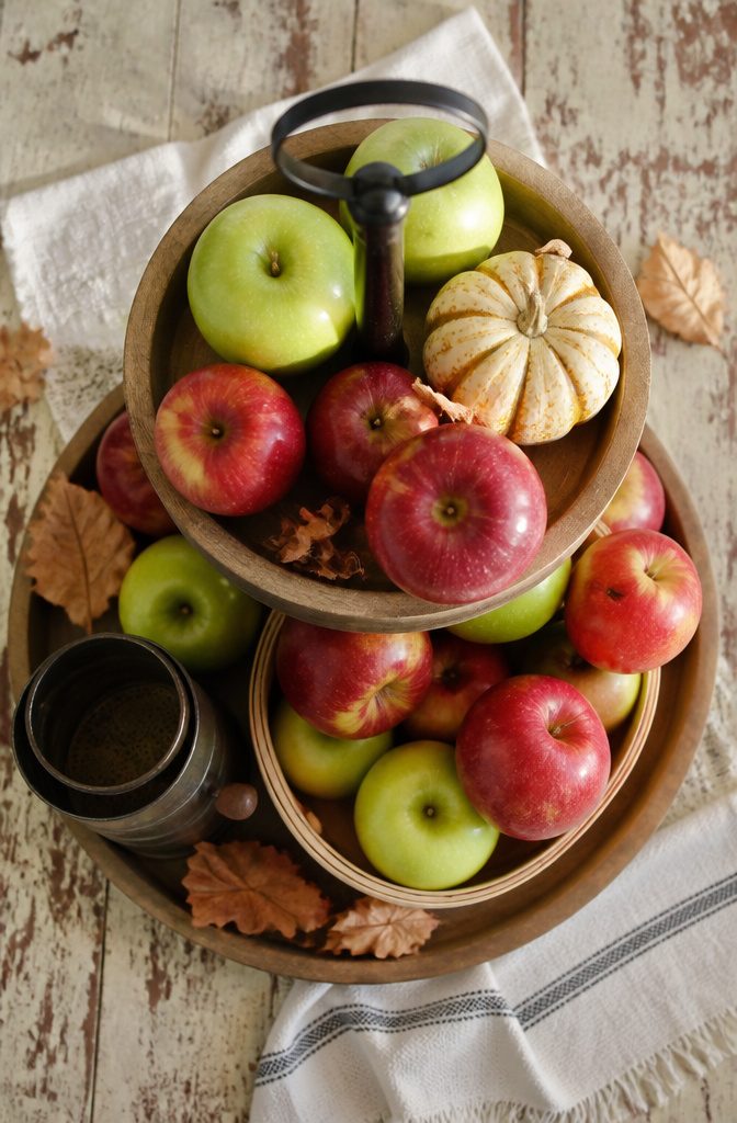 18 Fall Tray Decor Ideas for Coffee Tables, Tiered Trays & More 16 Green and red apples arranged on a tiered tray.