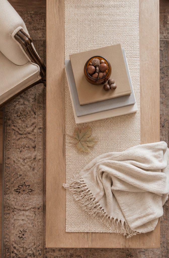 18 Fall Tray Decor Ideas for Coffee Tables, Tiered Trays & More 3 Neutral books with acorns and a small vase on a decorative tray.