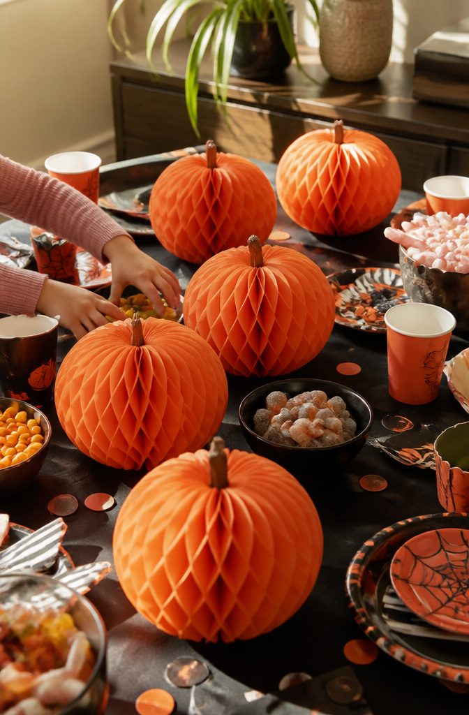 Six honeycomb pumpkins arranged on a children's table.